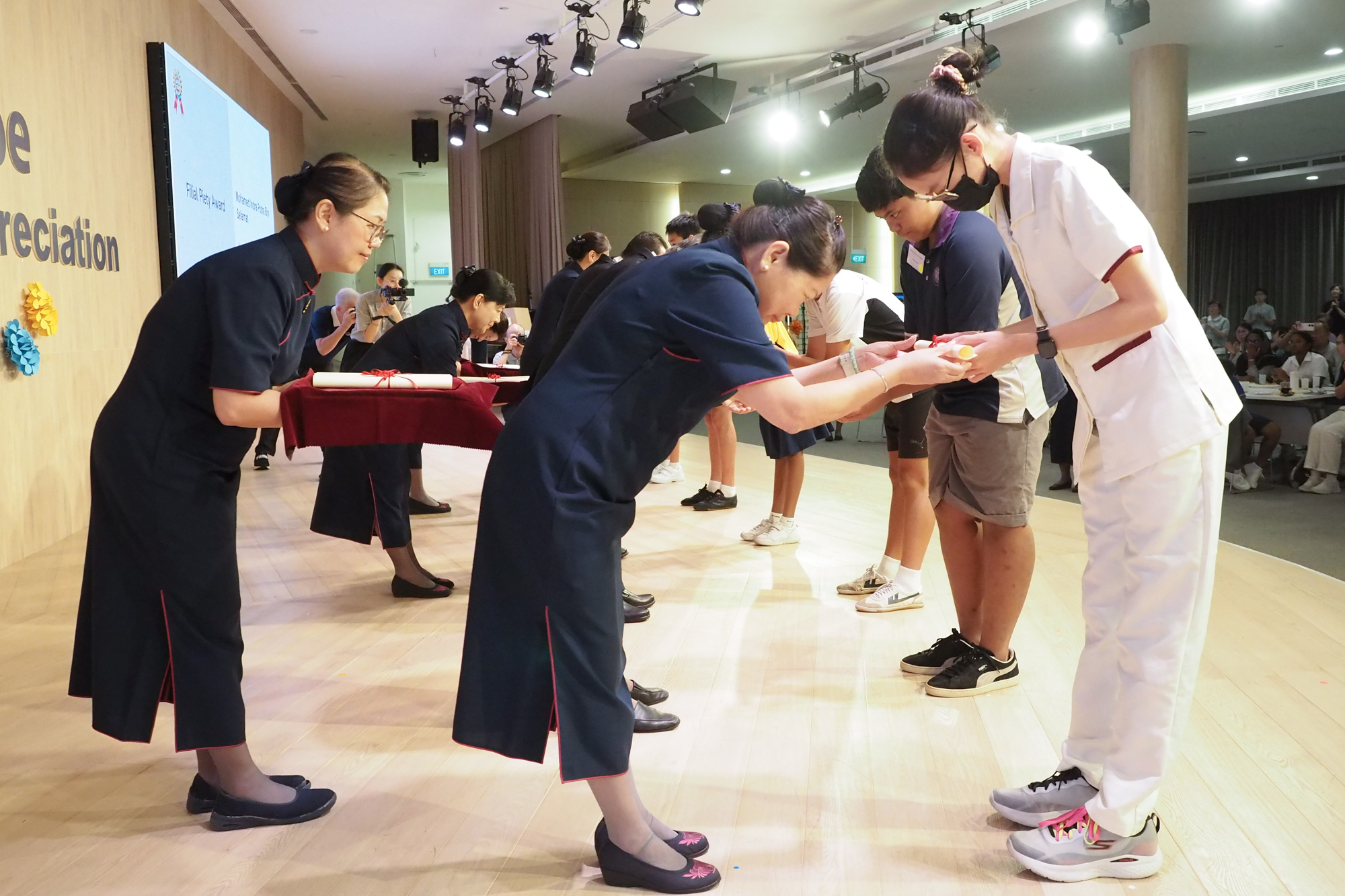 Award recipients take turns going onstage and exchange words of gratitude with the award presenters, creating a heartwarming scene. (Photo by Teo Moh Sang)