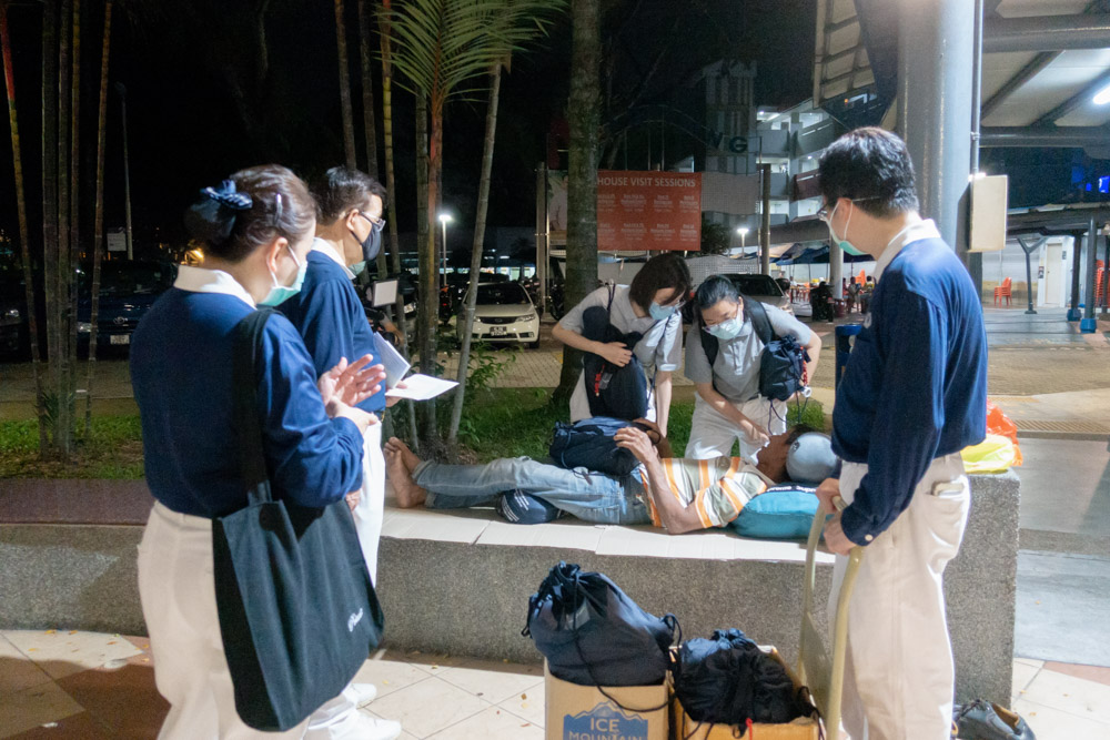 Tzu Chi staff and volunteers handing out care packages to stranded Malaysian workers who spent their nights beneath HDB flats. (Photo by Pang Lun Peng)