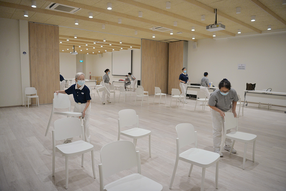 在人数限制的防疫措施下,社区志工一人当两人用,互相补位。